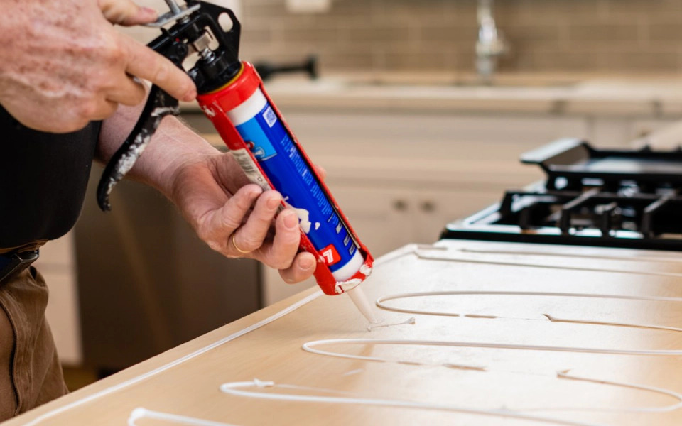 Worker applying some glue to a space